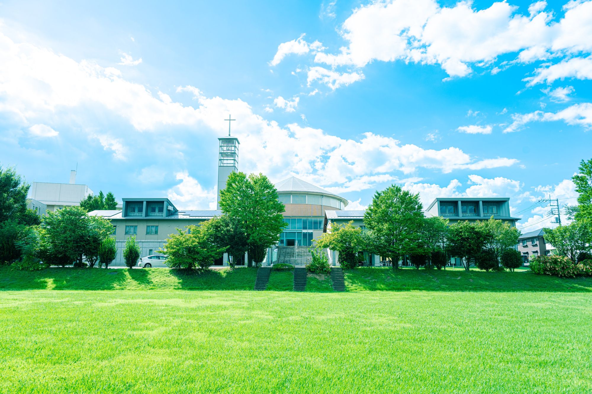 聖学院大学キャンパス全景　青空と芝生、十字塔のあるチャペル